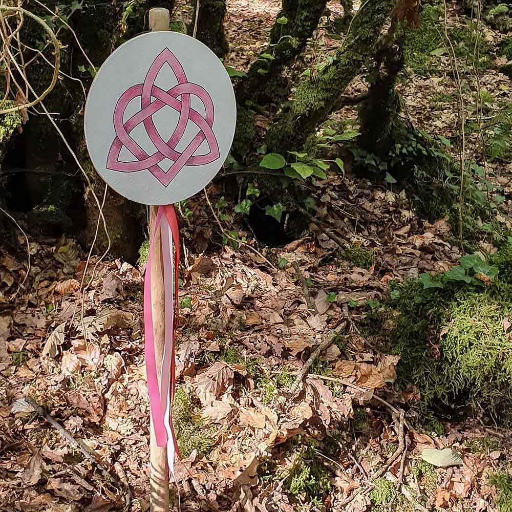 Il y a un panneau circulaire marqué d’un symbole pour honorer la Déesse Aliya, des rubans roses sont suspendus à l’occasion des célébrations druidiques de Dagdia.